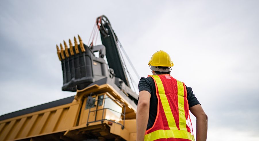 A heavy vehicle mechanic inspecting a large mining equipment