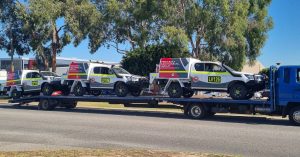 Mine-spec vehicles on transport truck, maintained by a light vehicle mechanic